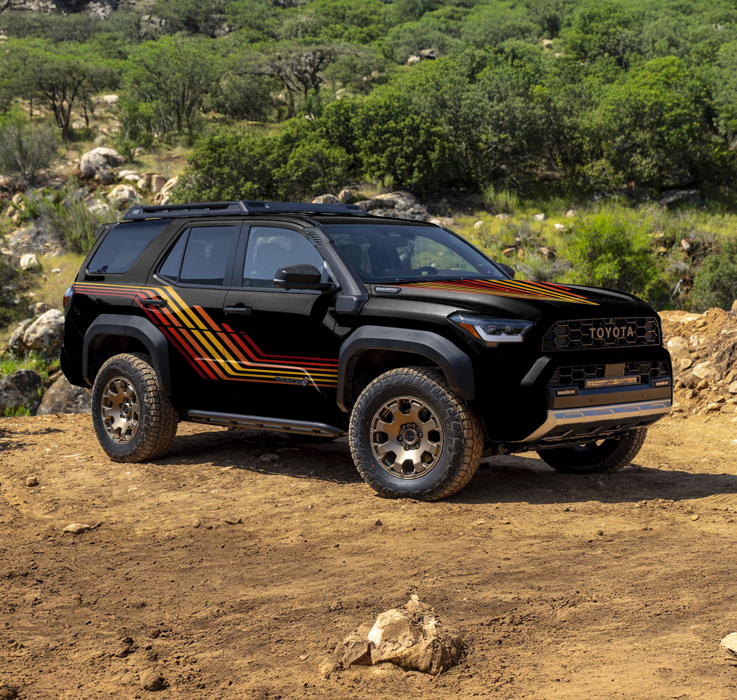 Black 4Runner on dirt trail in mountains. It has a 1980s style retro line wrap in yellow, red and orange.